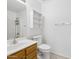 This bathroom offers a single sink, wood-finished vanity, and a white cabinet above the toilet at 1156 N San Benito Dr, Gilbert, AZ 85234