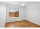 Bright bedroom features wood flooring, a ceiling fan, and backyard views at 1156 N San Benito Dr, Gilbert, AZ 85234