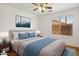 This staged bedroom features a queen bed, wood floors, and a window for natural light at 1156 N San Benito Dr, Gilbert, AZ 85234