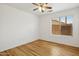 This bedroom has wood floors, a ceiling fan, and a window that provides natural light at 1156 N San Benito Dr, Gilbert, AZ 85234