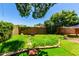 Backyard with grass, trees, brick fence, and stone walkway at 1509 E Verlea Dr, Tempe, AZ 85282