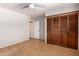Bedroom with a ceiling fan, door, wood floors and built in wooden closet at 1509 E Verlea Dr, Tempe, AZ 85282