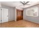 Bedroom with a ceiling fan, window, wood floors and built in wooden closet at 1509 E Verlea Dr, Tempe, AZ 85282
