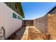 Enclosed side yard with a block wall and gravel, offering a low-maintenance outdoor area at 1509 E Verlea Dr, Tempe, AZ 85282