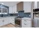 Well-lit kitchen with stainless steel appliances, patterned backsplash, and quartz countertops at 1530 W Glenrosa Ave, Phoenix, AZ 85015