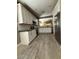 Modern kitchen features white cabinets, dark countertops, stainless steel appliances, and wood-look flooring at 15334 W Acapulco Ln, Surprise, AZ 85379