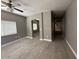 Open-concept living area with wood-look tile, a ceiling fan and an archway, offering a modern and spacious feel at 15334 W Acapulco Ln, Surprise, AZ 85379