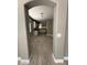 View through arched doorway into the kitchen area, showcasing wood-look flooring and neutral paint tones at 15334 W Acapulco Ln, Surprise, AZ 85379