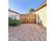 The front exterior of this home features desert landscaping and a wooden gate at 16176 W Lisbon Ln, Surprise, AZ 85379