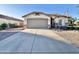 Attractive home featuring a desert landscape, an American flag, and a two-car garage at 16176 W Lisbon Ln, Surprise, AZ 85379