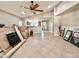 Spacious living room with tile flooring, ceiling fan, and adjacent view to the kitchen at 16176 W Lisbon Ln, Surprise, AZ 85379