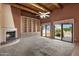 Spacious living room with wood beam ceilings, fireplace, built-ins, and sliding glass doors at 16927 E Trojan Ct, Fountain Hills, AZ 85268
