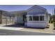 Exterior view of a mobile home featuring covered parking and a charming entrance, surrounded by low-maintenance landscaping at 17200 W Bell Rd # 812, Surprise, AZ 85374