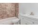 Bathroom featuring a white vanity with gold fixtures, shower/tub combo, and tan tiled shower at 17401 N 16Th Ave, Phoenix, AZ 85023