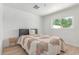 Bedroom with patterned quilt, gray headboard, and wood look flooring offers natural light at 17401 N 16Th Ave, Phoenix, AZ 85023