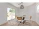 Bright dining area with wood look tile floors and a modern light fixture, sliding doors to backyard at 17401 N 16Th Ave, Phoenix, AZ 85023