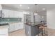 Modern kitchen with white cabinets, stainless steel appliances, and an island with bar seating at 17401 N 16Th Ave, Phoenix, AZ 85023