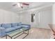 Bright living room with white brick walls, wood look tile floors, and a cozy blue sectional sofa at 17401 N 16Th Ave, Phoenix, AZ 85023