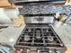 Close up of stainless steel gas range with mosaic backsplash, and granite countertops at 18026 N Cave Creek Rd # 16, Phoenix, AZ 85032