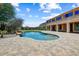 Beautiful backyard with a sparkling pool, rock waterfall, and lush landscaping at 18207 W Sells Dr, Goodyear, AZ 85395