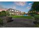 Backyard at dusk showcasing a stunning pool and lush greenery at 18207 W Sells Dr, Goodyear, AZ 85395