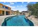 Beautiful backyard with a sparkling pool, rock waterfall, and lush landscaping at 18207 W Sells Dr, Goodyear, AZ 85395