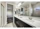 Bathroom featuring double sinks, a shower, and neutral tile floors at 18207 W Sells Dr, Goodyear, AZ 85395