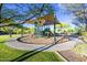 View of a community playground featuring playground equipment, shade canopy, and green grass at 18207 W Sells Dr, Goodyear, AZ 85395
