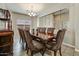Elegant dining room featuring a large table, decorative chandelier, and a built-in cabinet at 18207 W Sells Dr, Goodyear, AZ 85395