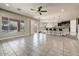 Large living room with tile floors, fan, and kitchen view with island and barstool seating at 18207 W Sells Dr, Goodyear, AZ 85395