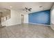 Open living room featuring designer accent wall, tile flooring and lots of natural light at 18207 W Sells Dr, Goodyear, AZ 85395