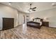 Spacious primary bedroom showcasing a ceiling fan, wood-look floors, and a door to the outside at 18207 W Sells Dr, Goodyear, AZ 85395