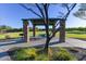 Community park pavilion featuring a metal roof, stone pillars, picnic table, and built-in barbecue at 18207 W Sells Dr, Goodyear, AZ 85395