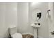 Stylish powder room with pedestal sink, modern fixtures, and tile flooring at 18207 W Sells Dr, Goodyear, AZ 85395