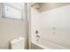 Bright bathroom with white shower-tub combination, bronze fixtures, and tiled walls at 18207 W Sells Dr, Goodyear, AZ 85395