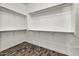 Walk-in closet with custom shelving and wood-look flooring at 18207 W Sells Dr, Goodyear, AZ 85395