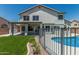 Stunning view of the back exterior, featuring a covered patio, pool, and beautifully landscaped yard at 1847 W Leah Ln, Gilbert, AZ 85233