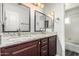 Double vanity bathroom with granite counters, dark cabinets and dual mirrors at 1847 W Leah Ln, Gilbert, AZ 85233