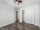 A bedroom with hardwood floors and a closet with doors, a fan, and white walls at 1847 W Leah Ln, Gilbert, AZ 85233