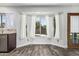 Cozy dining area featuring wood-look tile flooring and a bay window with white curtains at 1847 W Leah Ln, Gilbert, AZ 85233