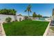 Spacious backyard features a lush lawn, mature palms, and a glimpse of the refreshing pool at 18820 N 33Rd Ave, Phoenix, AZ 85027