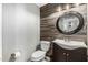 Powder bathroom featuring a vanity with wood accent wall and decorative mirror at 18820 N 33Rd Ave, Phoenix, AZ 85027