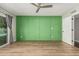 Bright bedroom featuring green accent wall, ceiling fan, and backyard access at 18820 N 33Rd Ave, Phoenix, AZ 85027