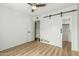 Bright bedroom features a wood-look floor, barn closet doors and an ensuite bath at 18820 N 33Rd Ave, Phoenix, AZ 85027