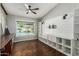 Bright home office with built-in shelving, a modern ceiling fan, and views of the pool area at 18820 N 33Rd Ave, Phoenix, AZ 85027