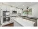 Modern white kitchen with stainless steel appliances, island, and farmhouse sink with black countertops at 18820 N 33Rd Ave, Phoenix, AZ 85027