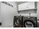 Laundry room features gray front loading washer and dryer, cabinets, and rack for hanging at 18820 N 33Rd Ave, Phoenix, AZ 85027