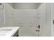 White tiled shower-tub combination with bronzed fixtures and a vanity to the left at 2000 N 36Th St # 20, Phoenix, AZ 85008