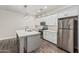 Kitchen features white cabinets, stainless steel appliances, kitchen island and wood floors at 2000 N 36Th St # 35, Phoenix, AZ 85008
