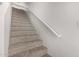 Carpeted staircase with white banister and neutral walls leading to the upper level at 2000 N 36Th St # 35, Phoenix, AZ 85008